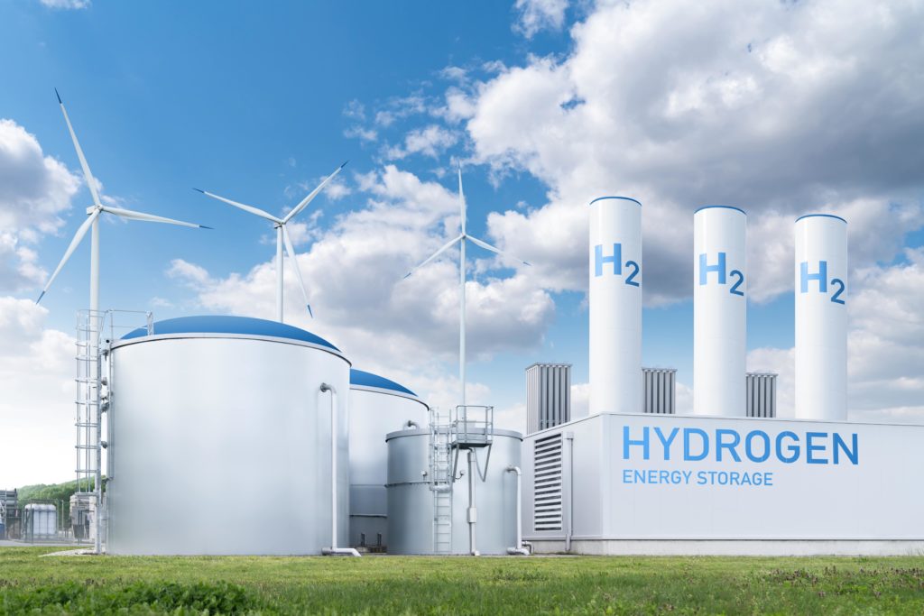 Modern hydrogen storage tanks and wind turbines, suggesting renewable energy integration and supporting the narrative of enhanced RFNBO Precertification standards for project maturity and compliance.